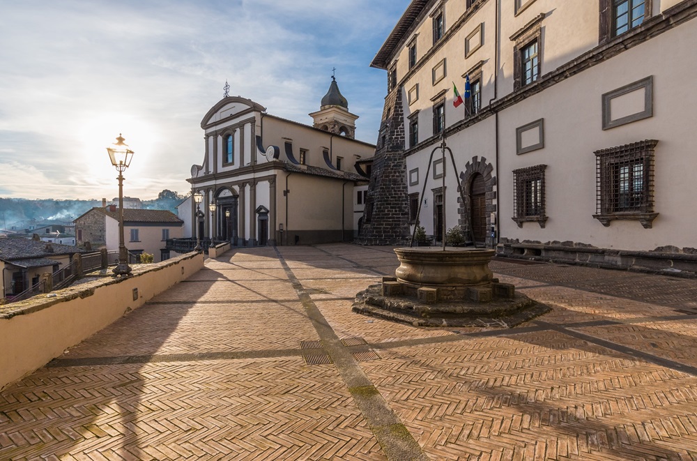 La Collegiata di Santa Maria Maddalena con il suo elegante campanile accanto al Palazzo Farnese di Gradoli