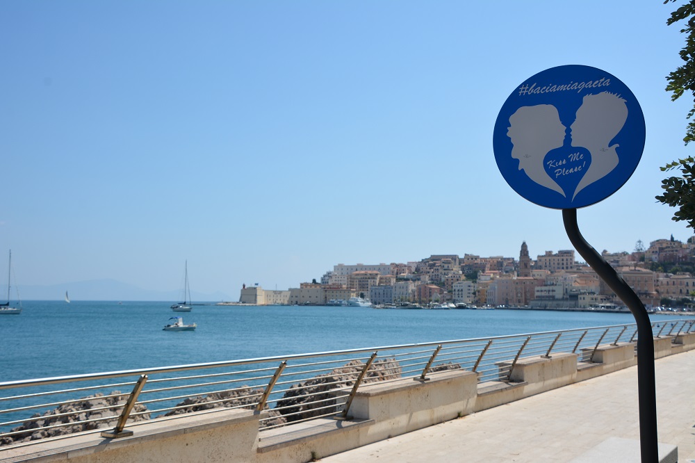 Il cartello blu con obbligo di baciarsi lungo Viale degli Innamorati a Gaeta